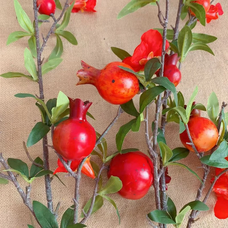 Dekorativer Granatapfel und Blumenzweig