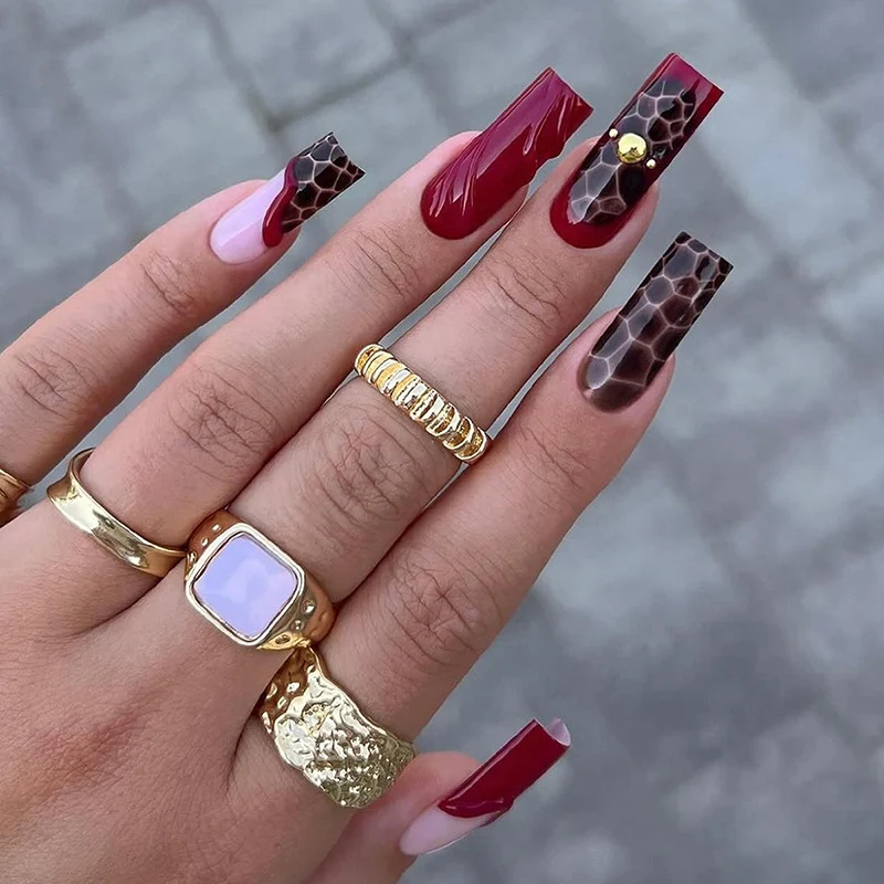 Kunstnagelset mit stilvollen marmorierten Designs und zarten Akzenten Karnz