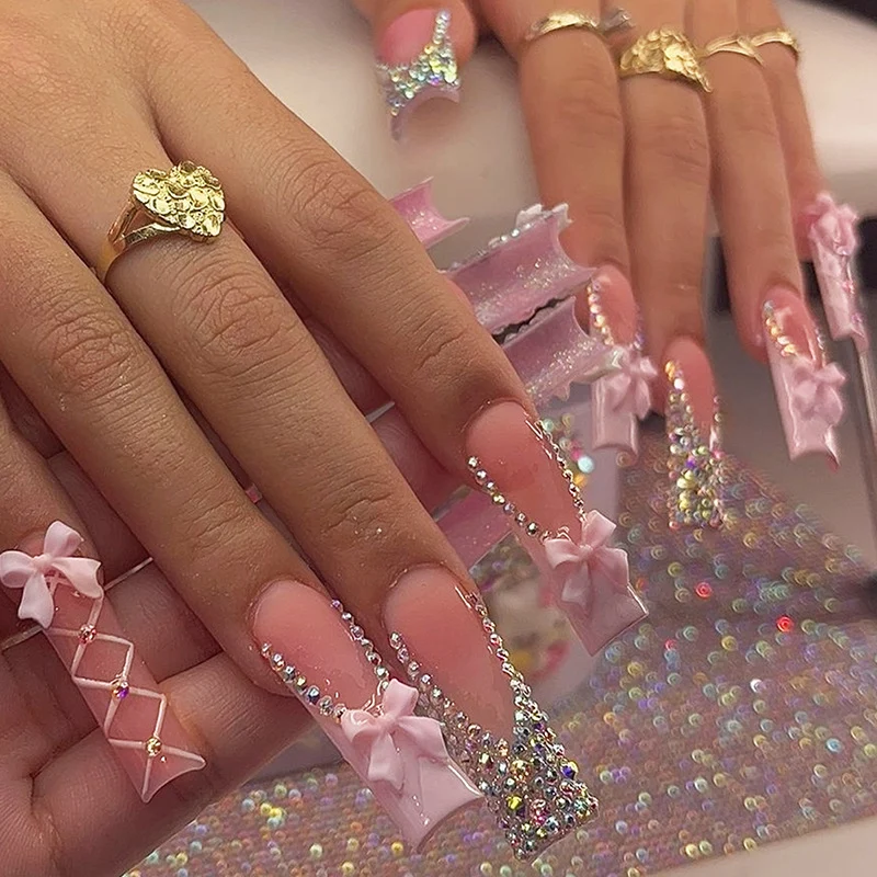 Kunstnagelset mit luxuriösen Strassverzierungen und Schleifenakzenten Karnz