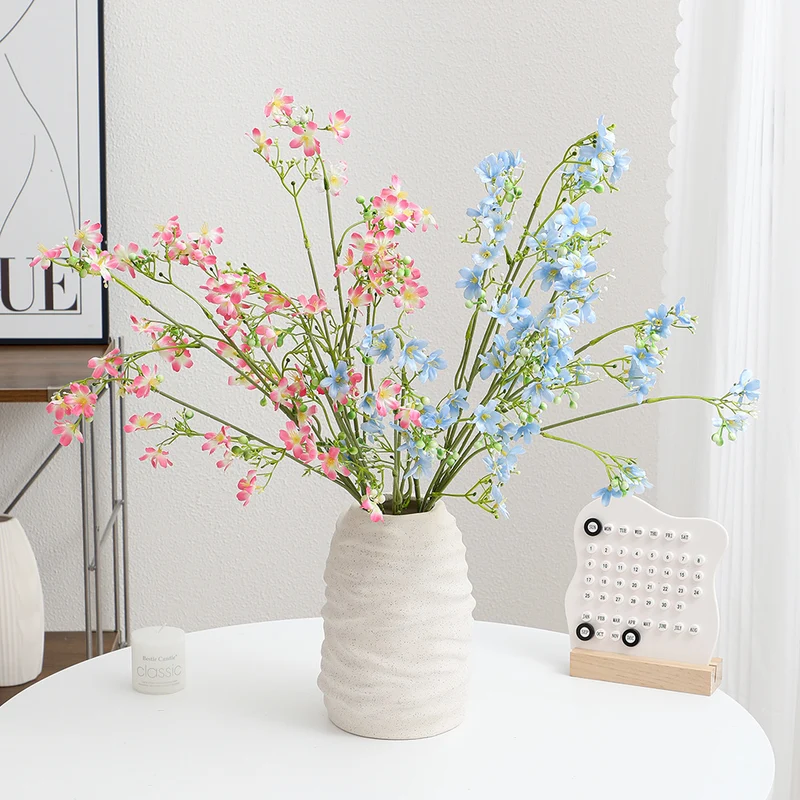 Künstlicher Blütenzweig mit zarten blauen Blumen und grünen Beeren Karnz
