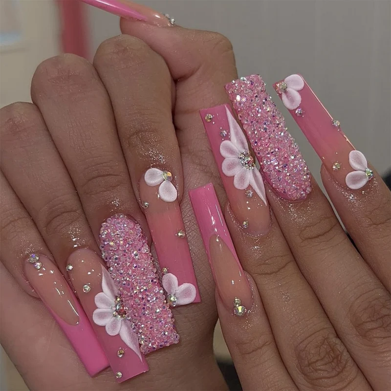 Kunstnagelset mit funkelnden Glitzer- und zarten Blumendekoren Karnz