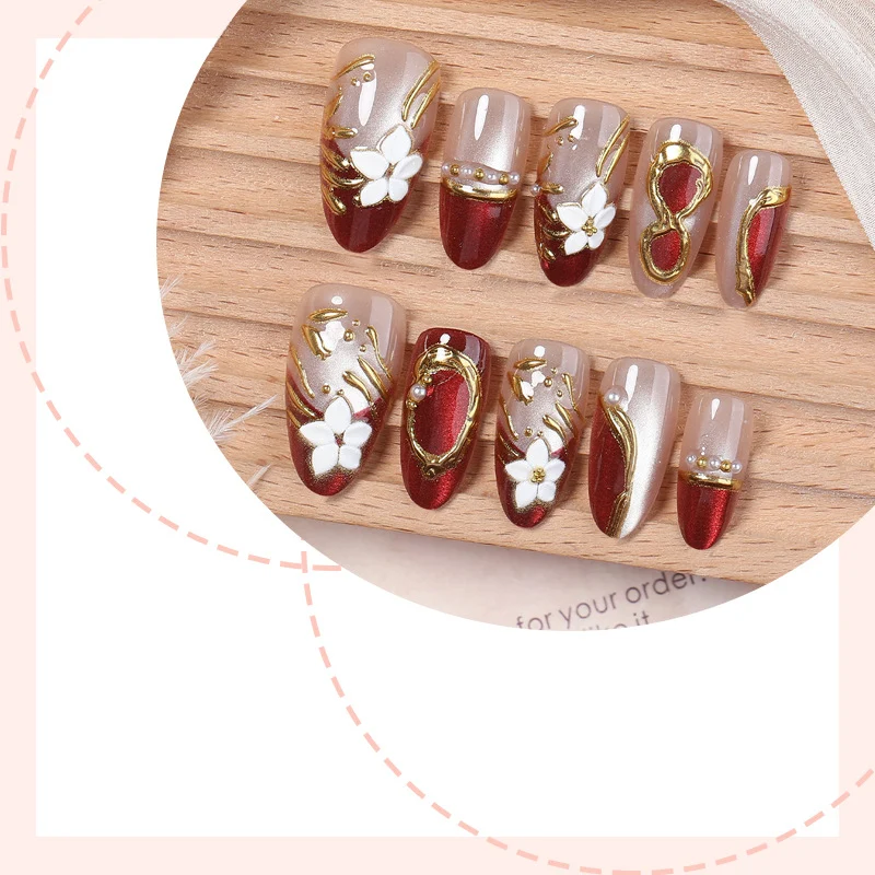 Kunstnagelset mit floralen und glamourösen Goldverzierungen Karnz