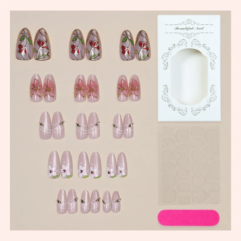 Kunstnagelset mit filigranen floralen Verzierungen und glänzenden Details Karnz