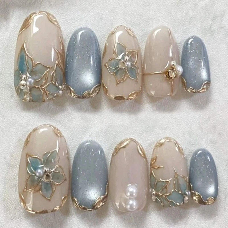 Kunstnagelset mit eleganten Blütenverzierungen und Glanz Karnz