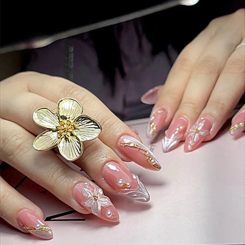 Kreatives Kunstnagelset mit eleganten floralen und glitzernden Verzierungen Karnz