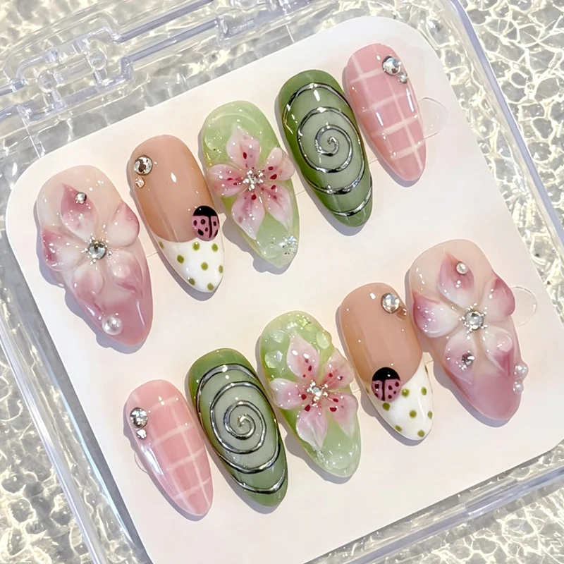 Kunstnagelset mit blumigen Akzenten und Glitzerdetails Karnz