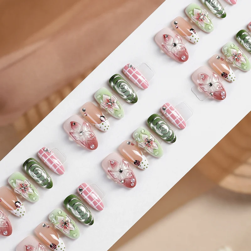 Kunstnagelset mit blumigen Akzenten und Glitzerdetails Karnz