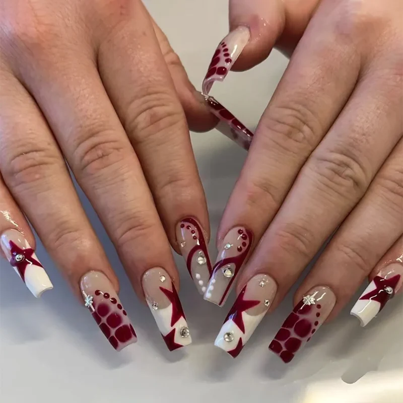 Kunstvolle Nagelverlängerungen mit Glitzer und Sternenmotiven Karnz