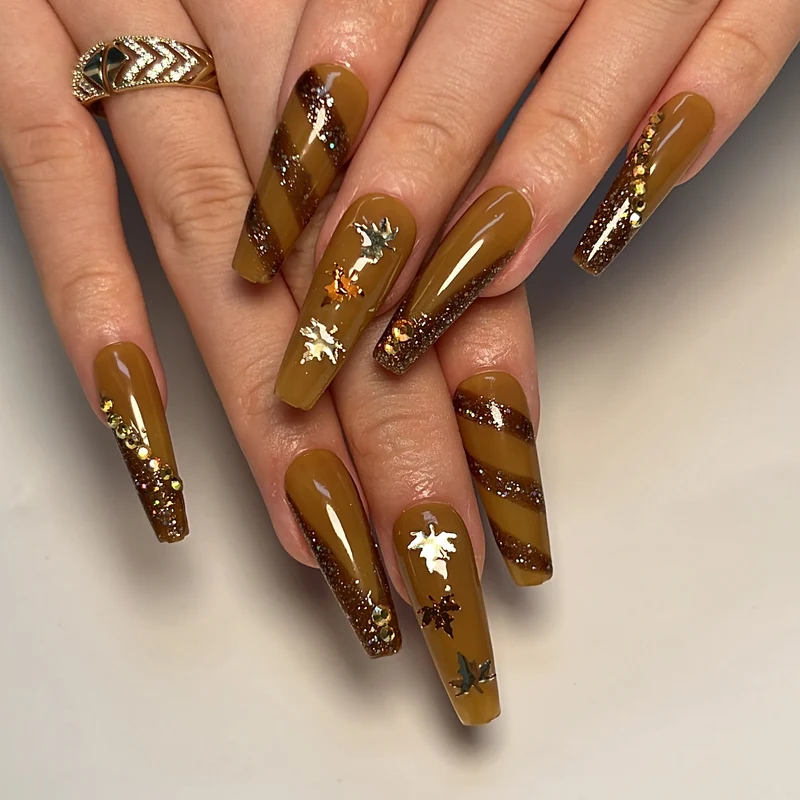 Kunstvolle Nagelkunst mit Glitter- und Blätterdesign Karnz