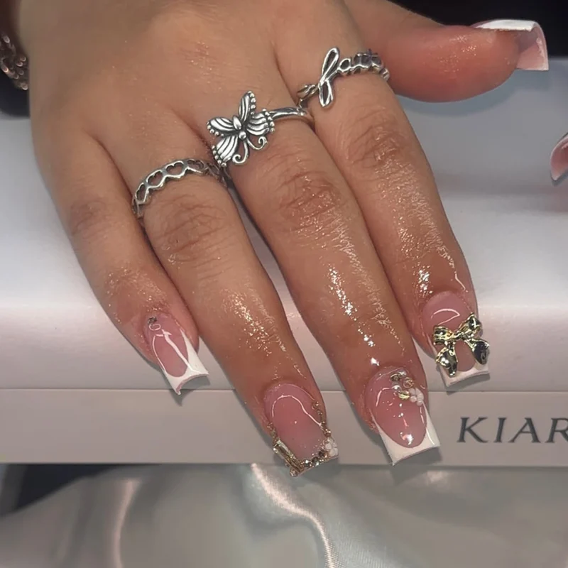 Kunstvolle Nagelkunst mit Blumen-Design und Blauem French Tip Karnz