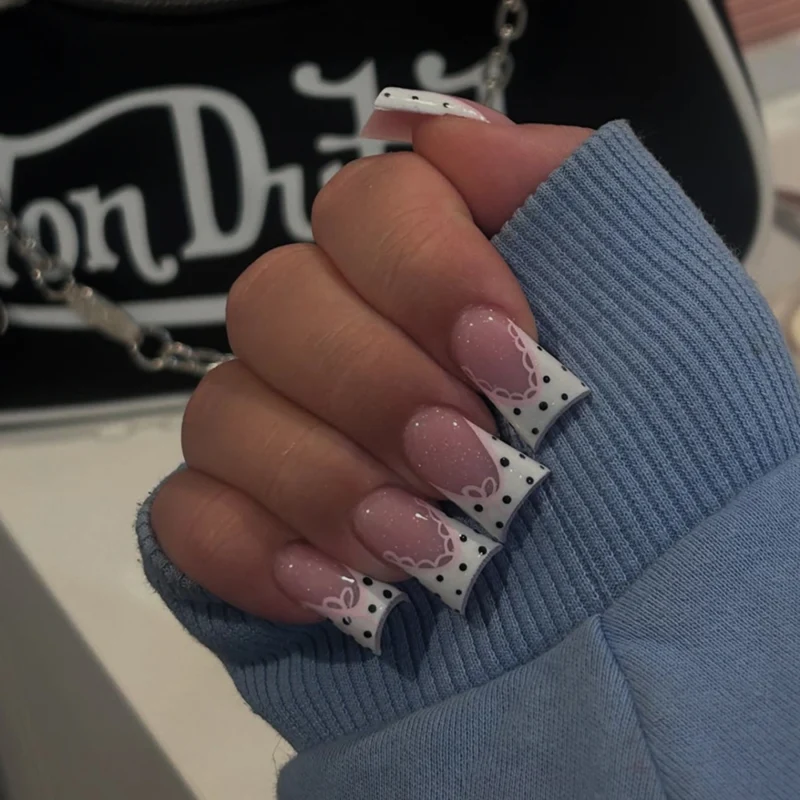 Kunstvolle Nagelkunst mit Blumen-Design und Blauem French Tip Karnz