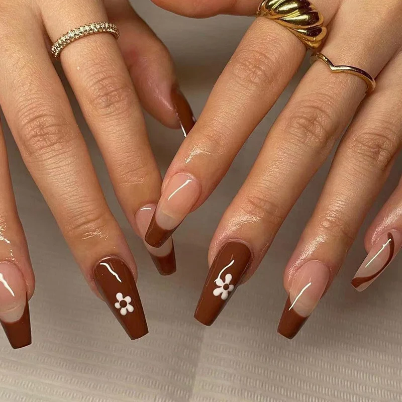 Kunstvolle Gel-Nägel mit elegantem Floral-Design und Glitzerakzenten Karnz