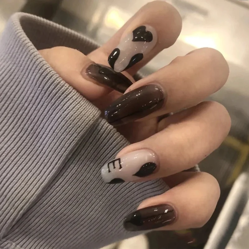 Kunstvolle Gel-Nägel mit elegantem Floral-Design und Glitzerakzenten Karnz