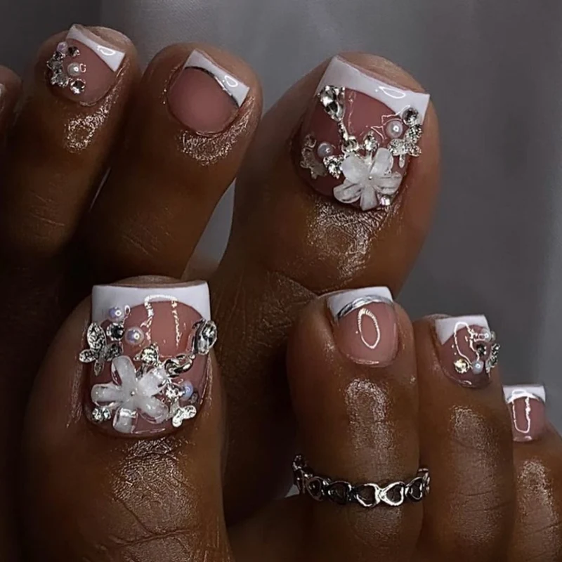Kunstvolle Fußnagelgestaltung mit eleganten Blüten- und Glitzerakzenten Karnz