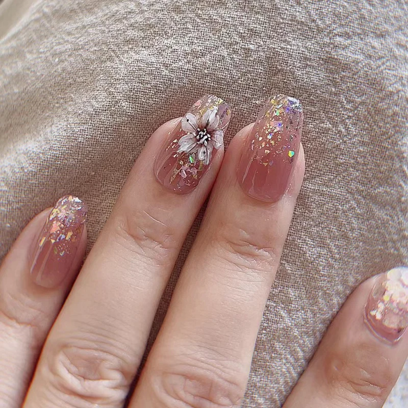 Künstliche Nagelverlängerungen mit floralem Design und Glitzerakzenten Karnz