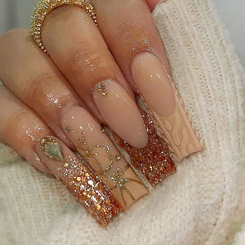 Glamouröses Kunstnagelset mit Glitzer und edlen Verzierungen Karnz