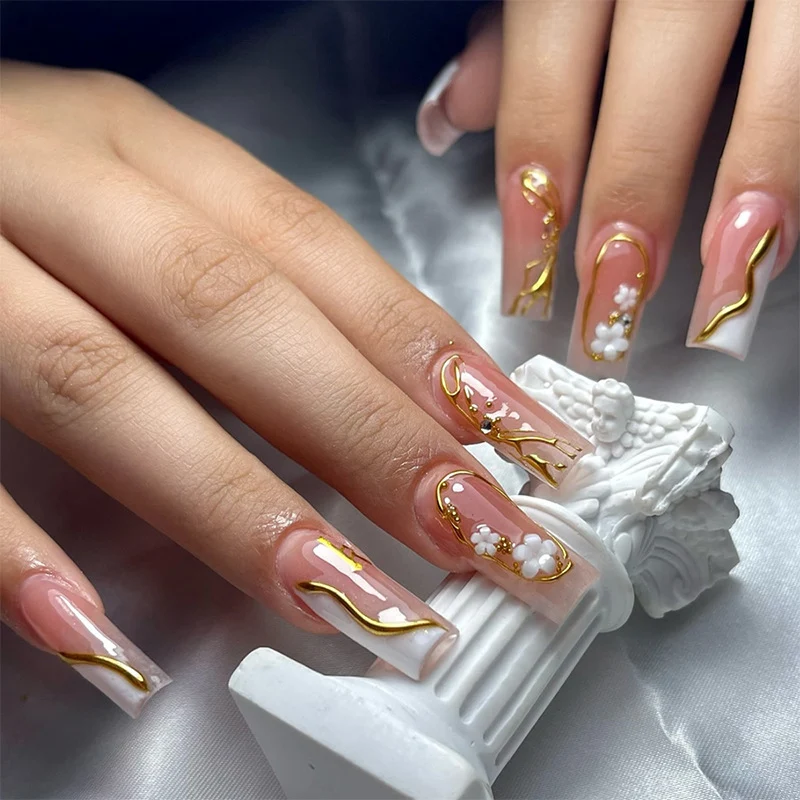 Elegantes Kunstnagelset mit goldenen Akzenten und floralen Details Karnz