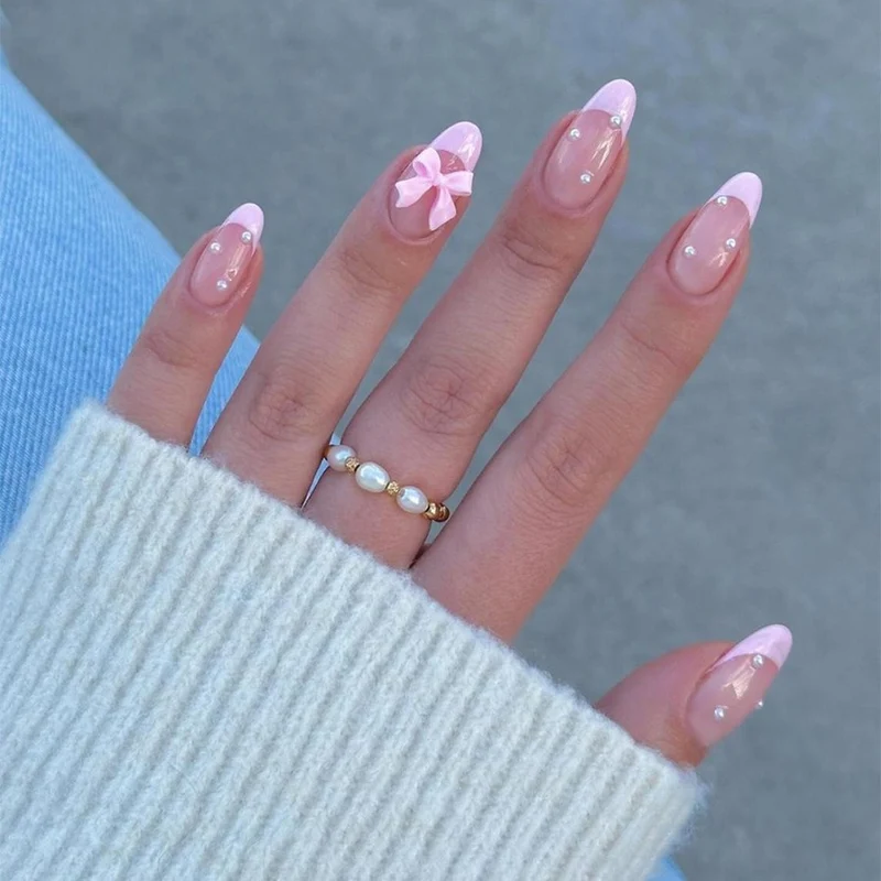 Kunstnagelset mit zarten Schleifen- und Glitzerakzenten Karnz