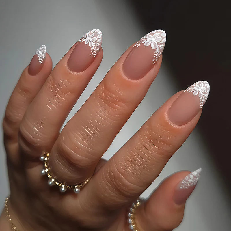 Kunstnagelset mit zarten Blütenverzierungen und durchscheinendem Finish Karnz