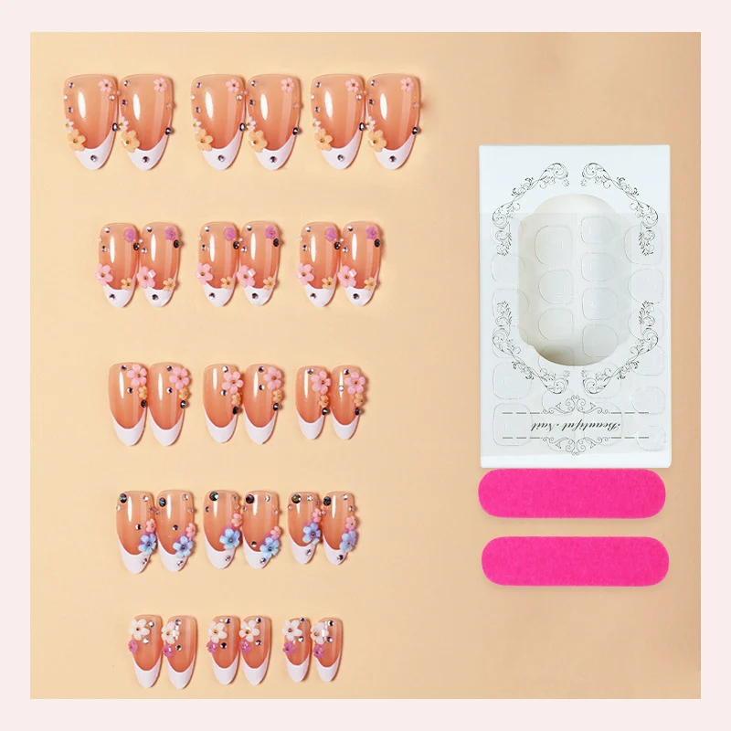 Kunstnagelset mit zarten Blumenverzierungen und funkelnden Strasssteinen Karnz